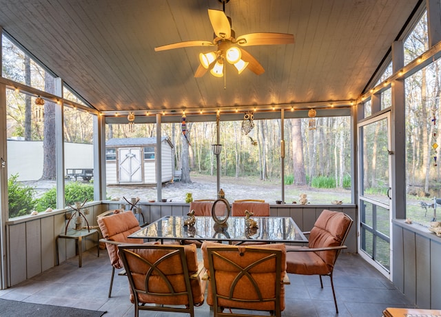 sunroom / solarium featuring lofted ceiling, rail lighting, ceiling fan, and wooden ceiling