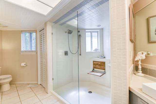 bathroom featuring vanity, toilet, a shower with shower door, and tile patterned floors