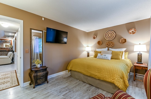 bedroom with light wood-type flooring and a textured ceiling