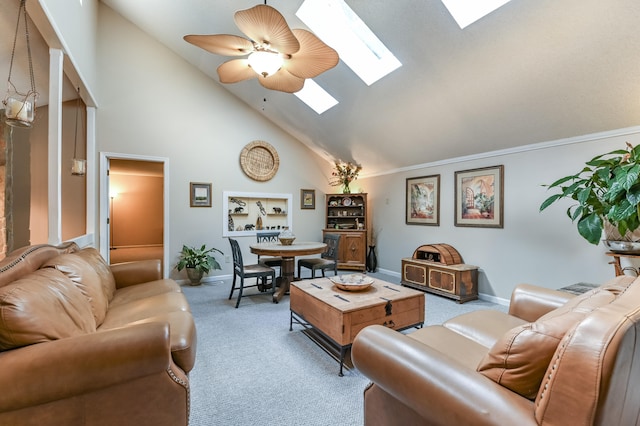 carpeted living room with crown molding, high vaulted ceiling, a skylight, and ceiling fan