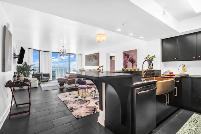 kitchen featuring dishwasher, floor to ceiling windows, an inviting chandelier, sink, and kitchen peninsula