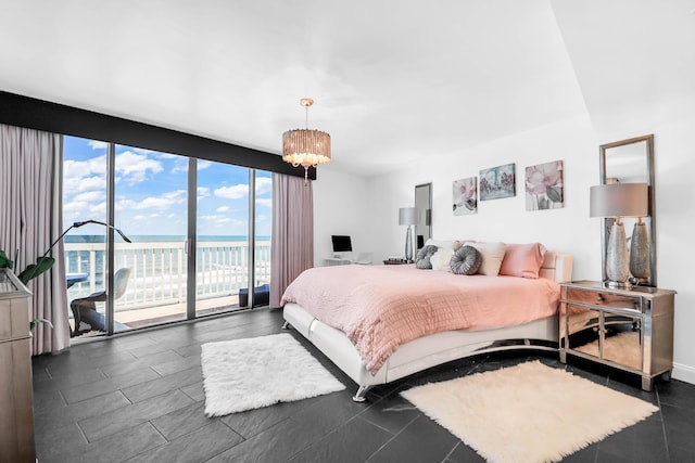 bedroom with access to outside, expansive windows, and an inviting chandelier