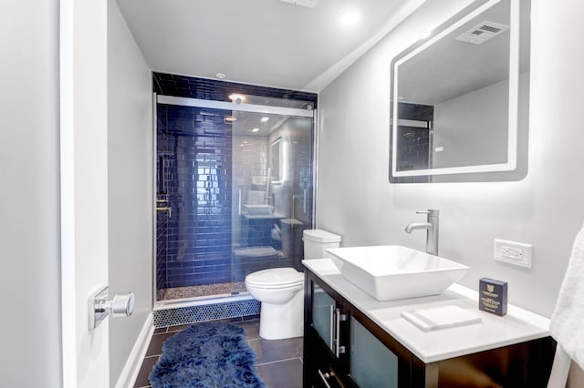 bathroom featuring tile patterned floors, vanity, toilet, and walk in shower