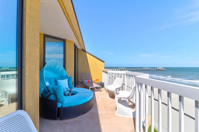 balcony featuring a water view and a beach view