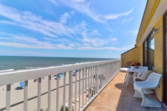 balcony featuring a water view and a beach view