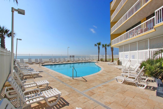 view of swimming pool with a patio area and a water view