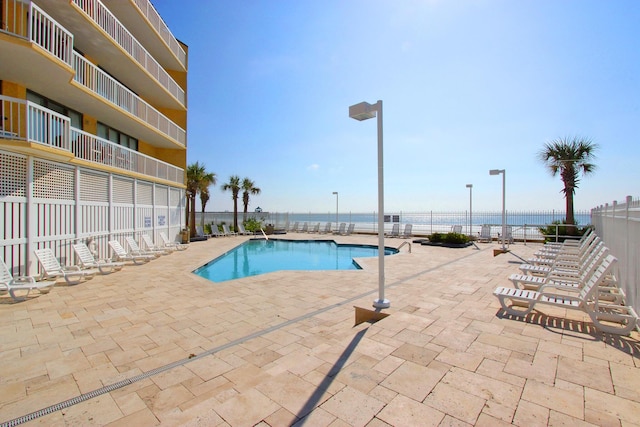 view of pool with a patio area and a water view