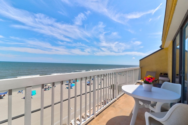 balcony with a water view and a view of the beach