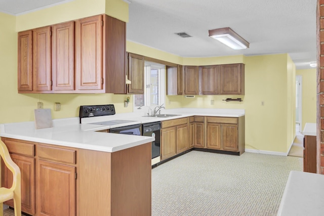 kitchen with visible vents, dishwasher, a sink, a peninsula, and stove