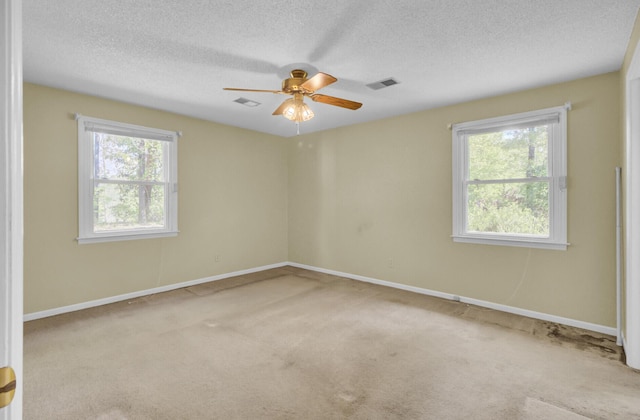 unfurnished room featuring a textured ceiling, carpet, and visible vents