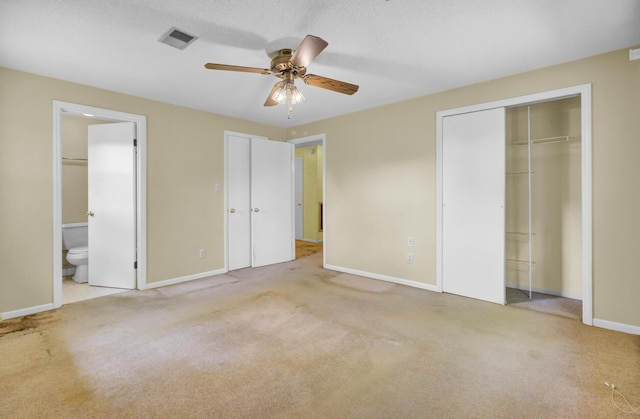 unfurnished bedroom featuring baseboards, carpet, visible vents, and connected bathroom