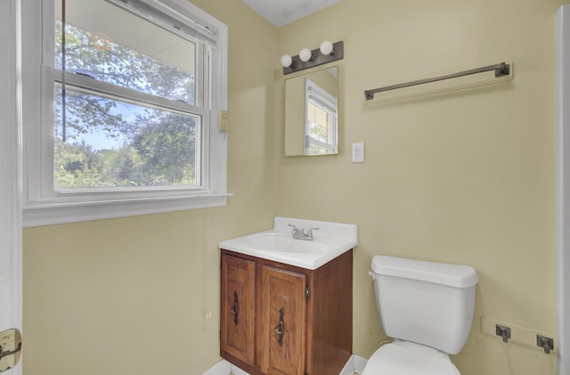 bathroom featuring vanity, toilet, and a healthy amount of sunlight