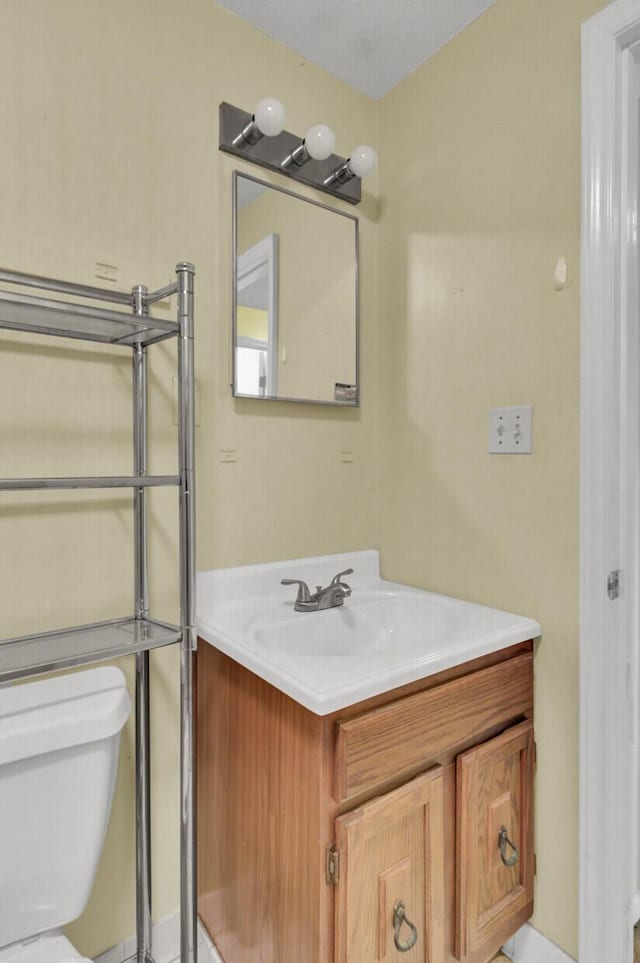 half bathroom with toilet and vanity