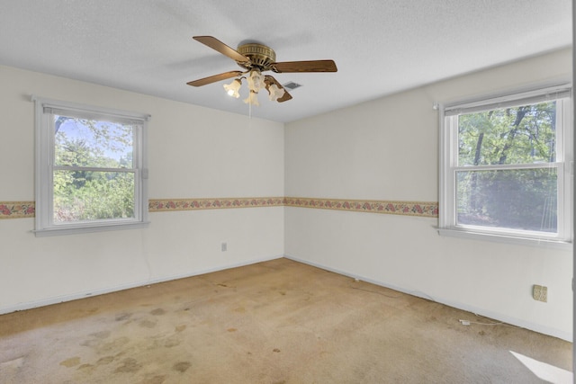 empty room with visible vents, ceiling fan, carpet flooring, and baseboards