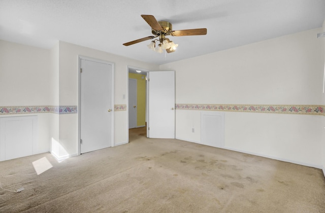 empty room with a ceiling fan and light colored carpet