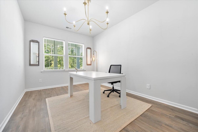 office space featuring wood-type flooring and a notable chandelier