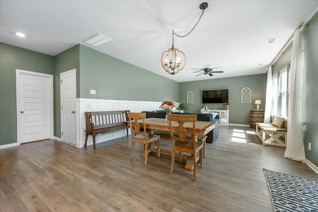 dining area featuring ceiling fan with notable chandelier and hardwood / wood-style flooring