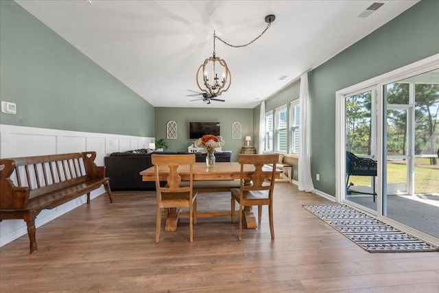 dining space featuring wood-type flooring and ceiling fan with notable chandelier