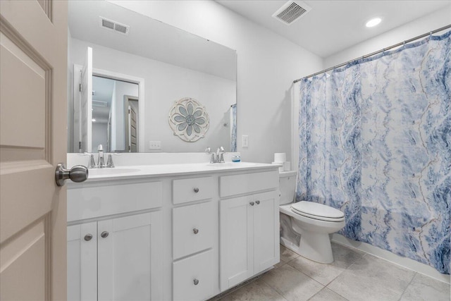 bathroom with tile patterned flooring, vanity, and toilet