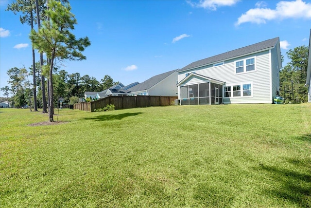 rear view of house featuring a sunroom and a lawn