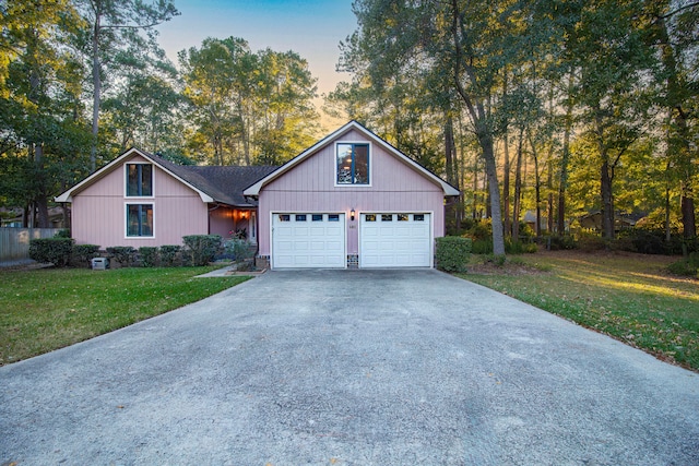 view of front of home with a garage and a yard