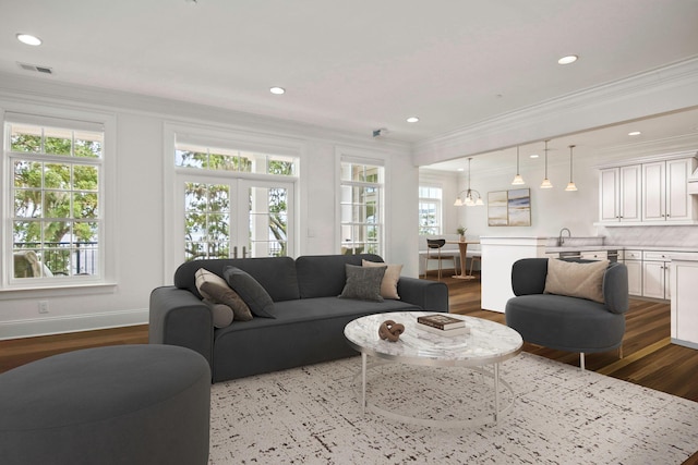 living room featuring crown molding, hardwood / wood-style floors, and a wealth of natural light