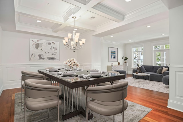 dining space with beamed ceiling, coffered ceiling, crown molding, and hardwood / wood-style flooring