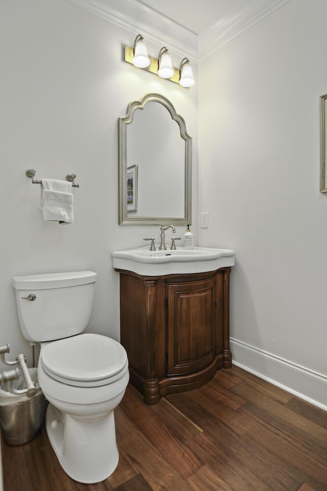 bathroom with crown molding, vanity, toilet, and hardwood / wood-style floors