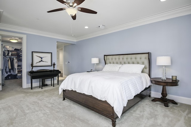 bedroom featuring light carpet, a closet, a spacious closet, and crown molding