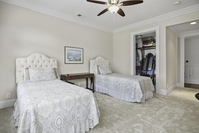 bedroom featuring a closet, ornamental molding, a spacious closet, and light carpet