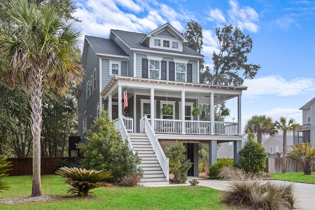 beach home featuring a front yard and covered porch