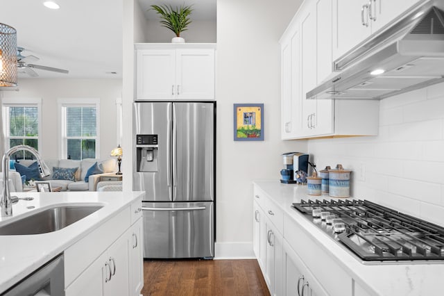 kitchen featuring sink, white cabinets, dark hardwood / wood-style flooring, decorative backsplash, and stainless steel appliances