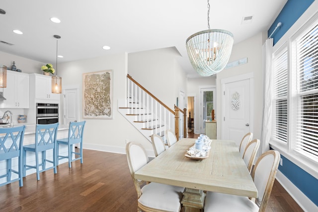 dining area with dark hardwood / wood-style floors, a chandelier, and sink