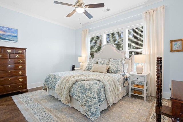 bedroom with hardwood / wood-style floors, ornamental molding, and ceiling fan