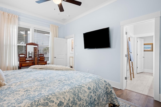 bedroom with crown molding, ceiling fan, and wood-type flooring