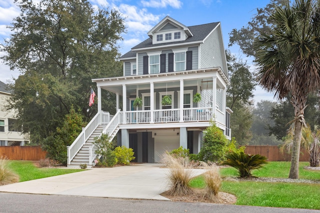 beach home featuring a garage, covered porch, and a front lawn