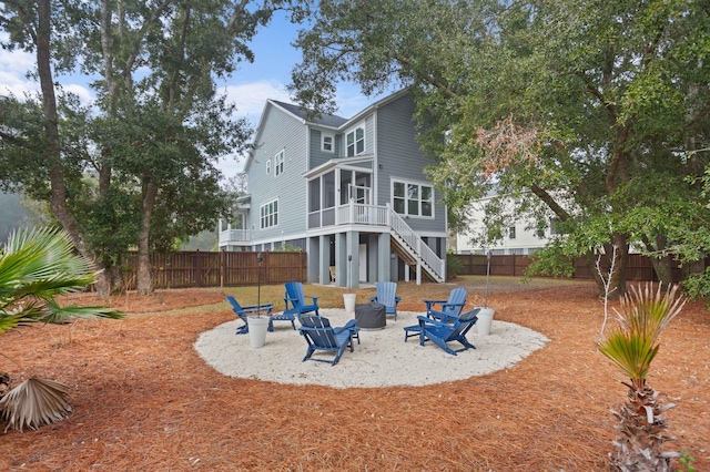 rear view of house featuring a sunroom and a fire pit