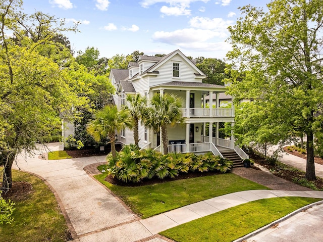 11 Dalton St, Daniel Island, SC 29492 - view of front of home featuring a porch, a shingled roof, a front lawn, and a balcony