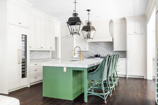 11 Dalton St, Daniel Island, SC 29492 - kitchen featuring a sink, light countertops, backsplash, dark wood-type flooring, and an island with sink
