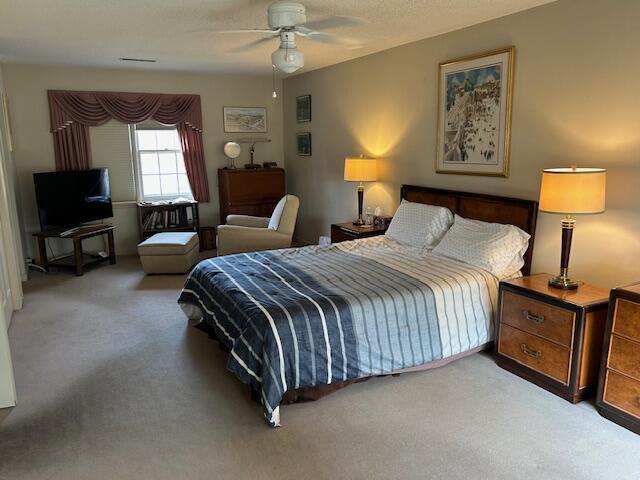 bedroom featuring a ceiling fan and carpet