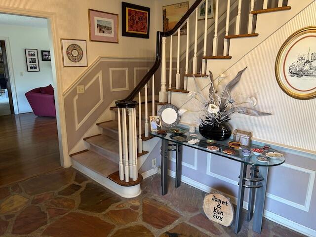stairs featuring a decorative wall and a wainscoted wall