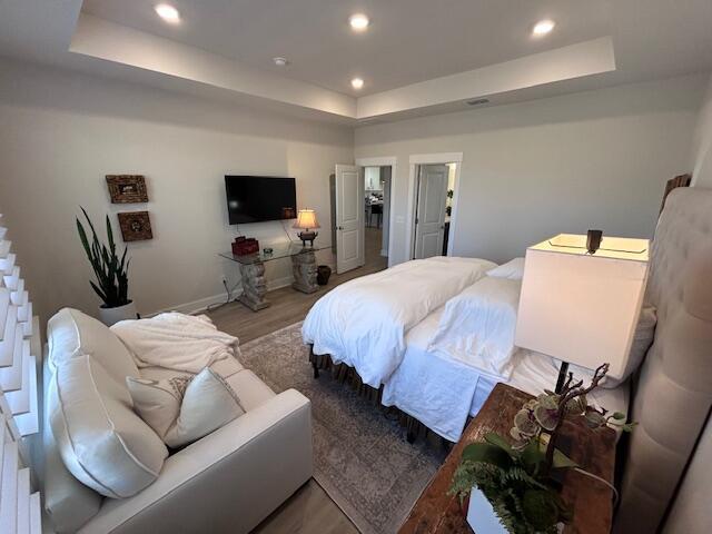 bedroom featuring light hardwood / wood-style flooring and a raised ceiling