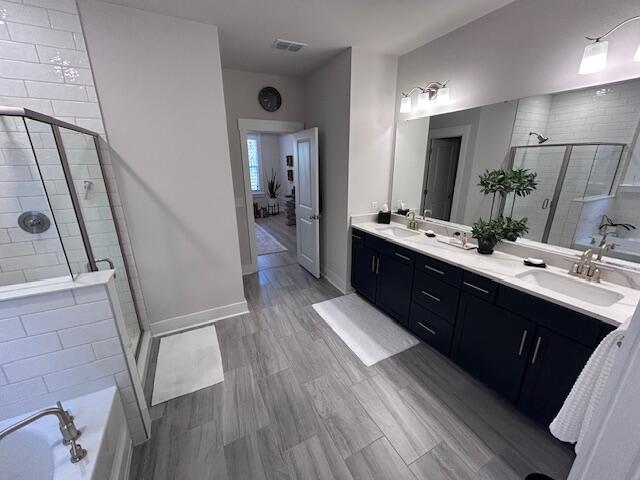 bathroom featuring hardwood / wood-style flooring, vanity, and separate shower and tub