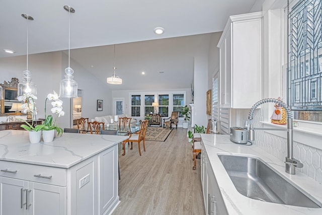 kitchen featuring white cabinetry, sink, and decorative light fixtures