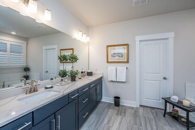 bathroom with vanity, hardwood / wood-style floors, and a tub