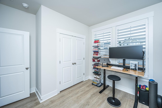 home office with light hardwood / wood-style flooring