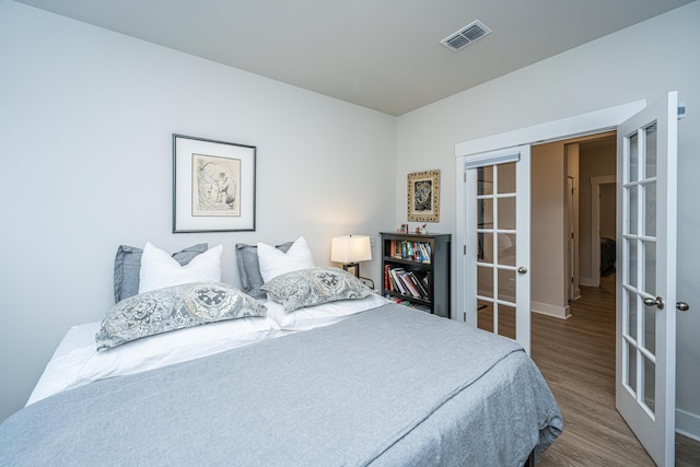 bedroom featuring french doors and hardwood / wood-style floors
