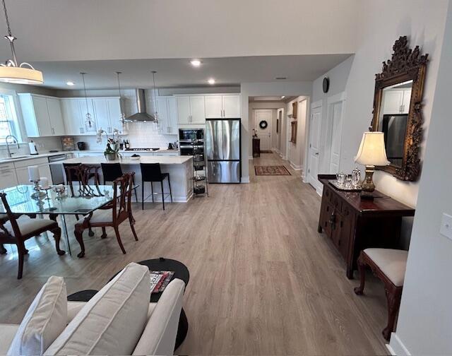 living room with sink and light wood-type flooring