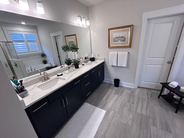 bathroom featuring vanity, independent shower and bath, and wood-type flooring