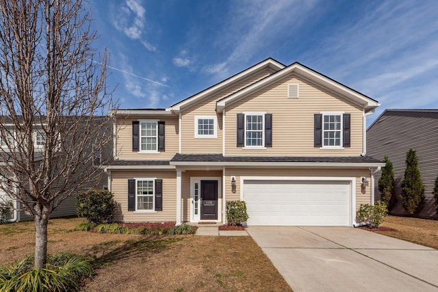 traditional home featuring driveway, an attached garage, and a front yard